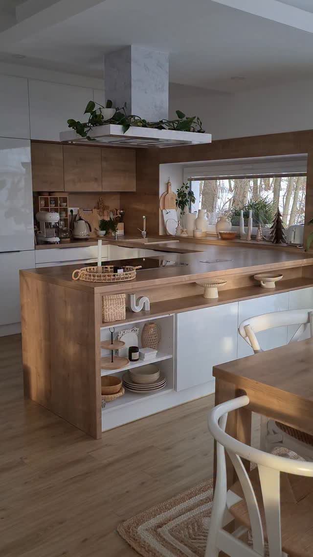 Modern kitchen with light wood island, white cabinets, and integrated dining area.