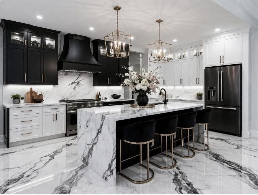 Modern black and white kitchen with marble floors and a large marble island.