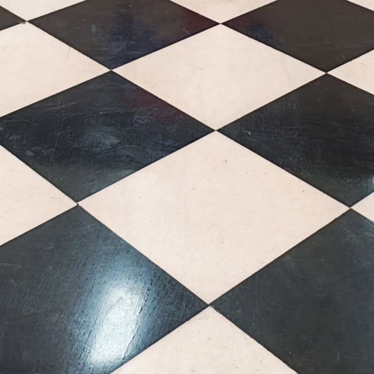 Black and white checkerboard tiled floor with a polished, reflective finish.