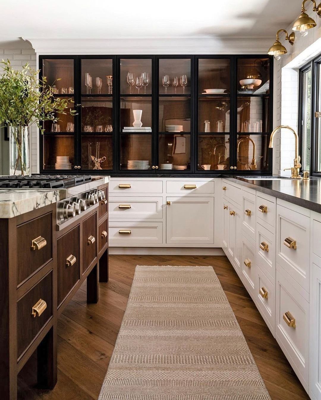 Kitchen cabinets and faucet featuring polished brass hardware and gold-toned fixtures.