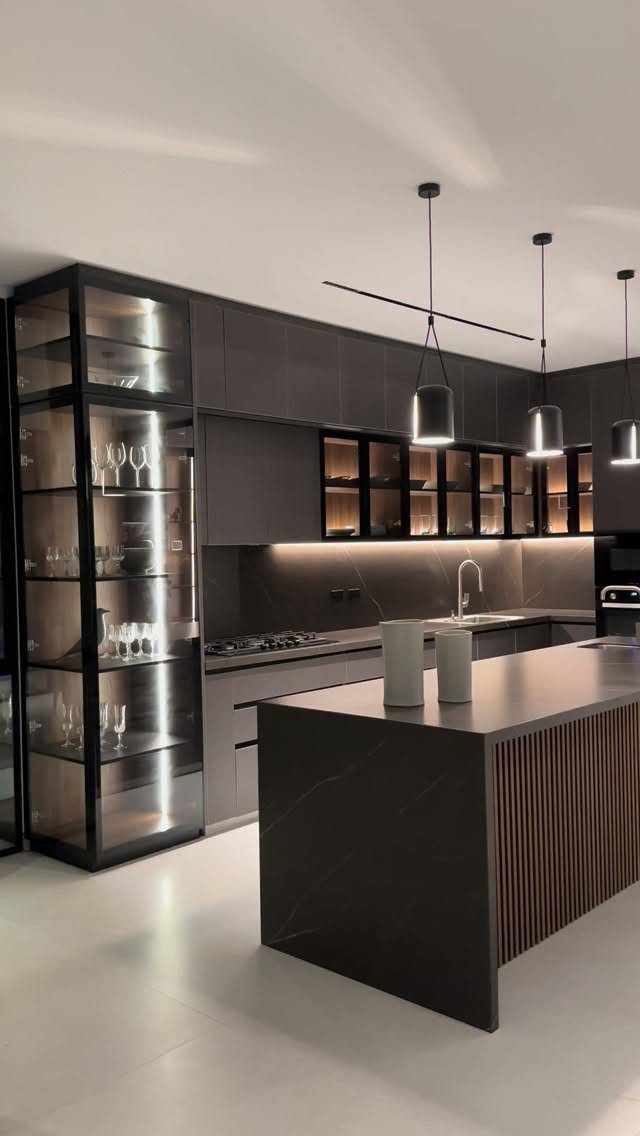 Modern kitchen with dark cabinetry, a black island with wood slats, and glass cabinets.