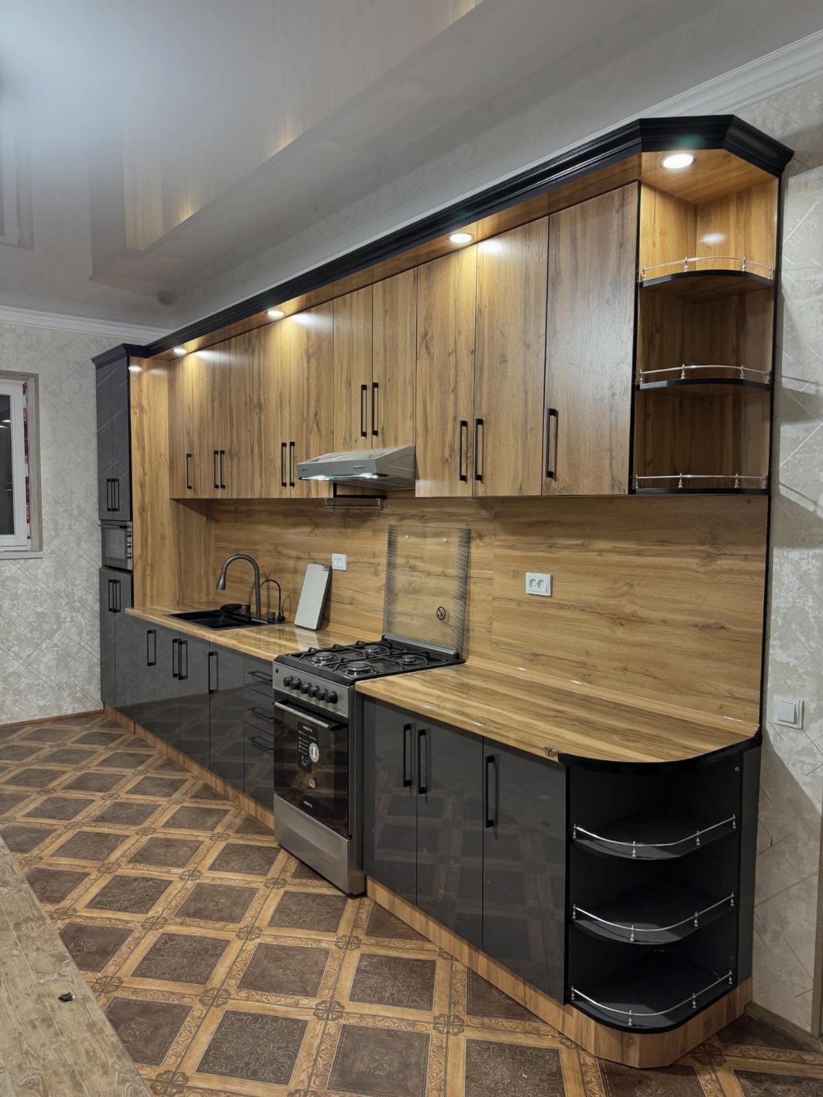 Two-tone kitchen cabinets with light wood uppers and glossy black lowers and countertops.