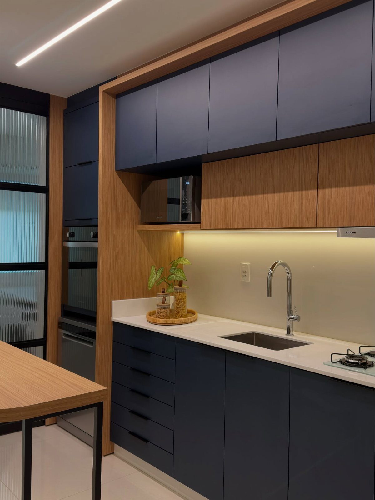 Navy blue kitchen cabinets paired with a clean white countertop and wooden accents.