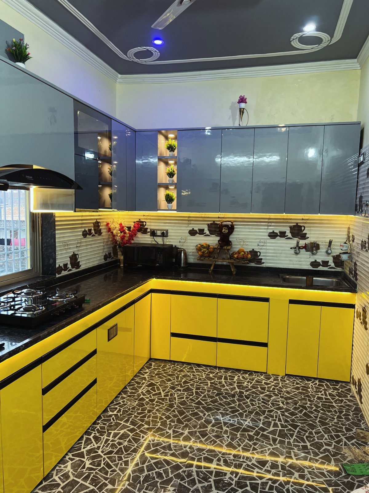 Butter yellow lower cabinets and gray upper cabinets in a modern kitchen setup.