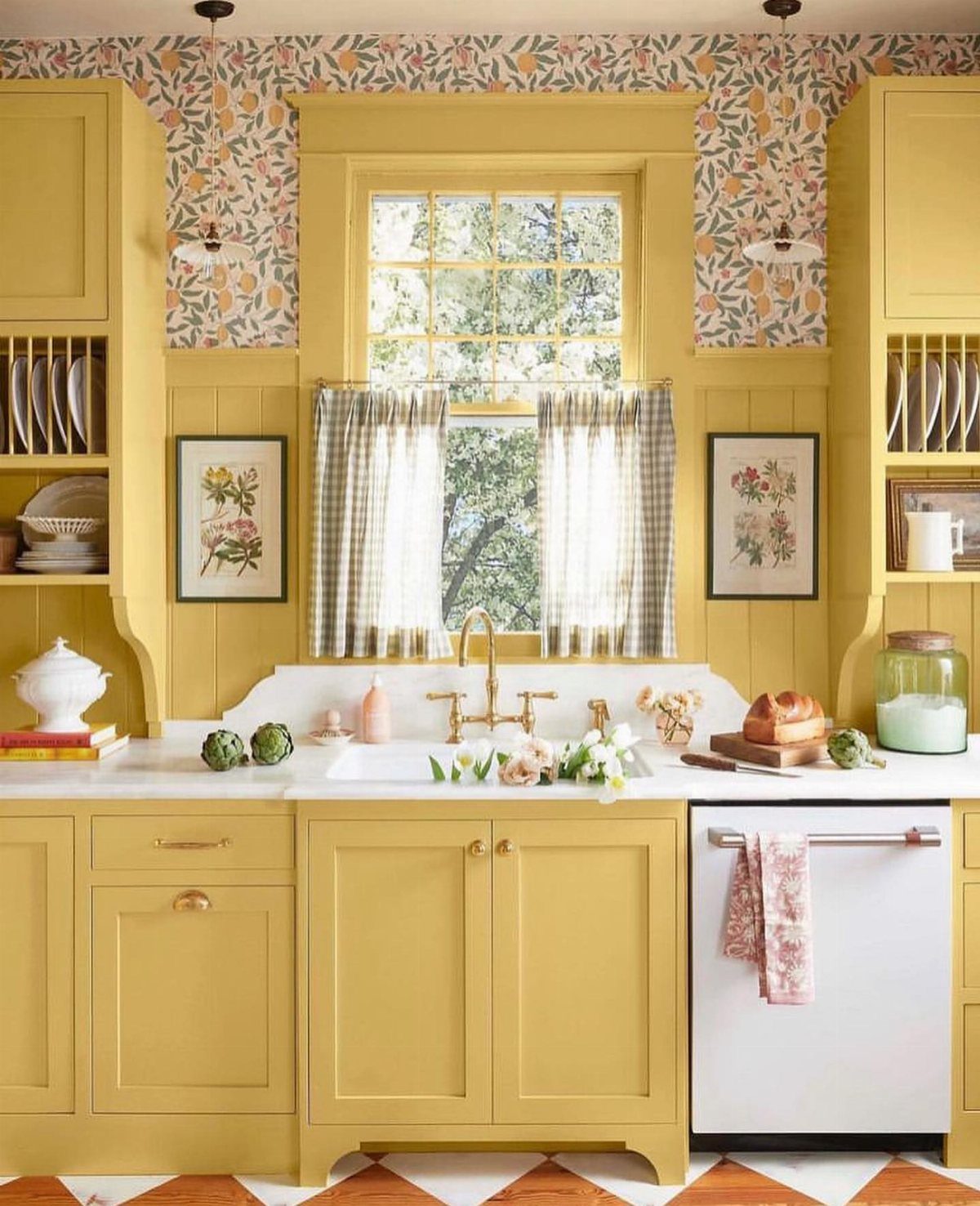Butter yellow kitchen cabinets with floral wallpaper and vintage-style decor and accessories.