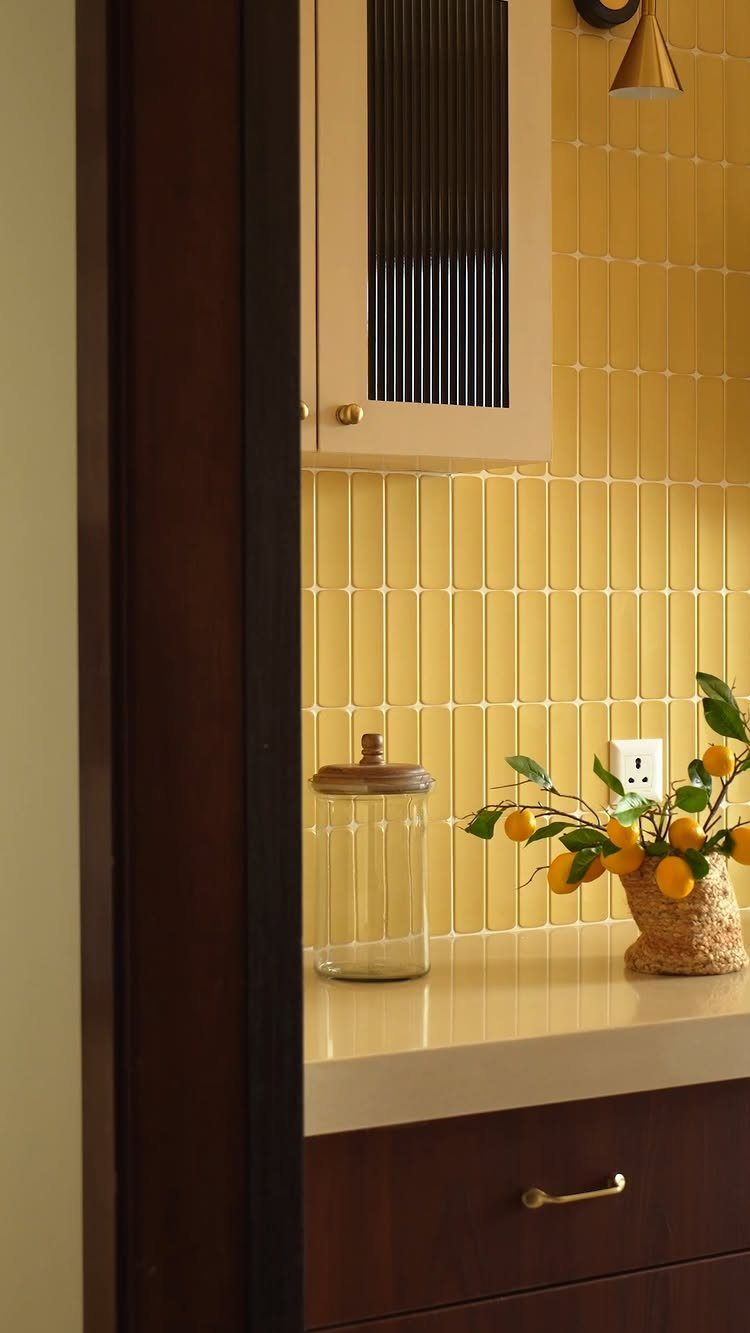 Butter yellow vertical wall tiles in a kitchen with lemons on the counter