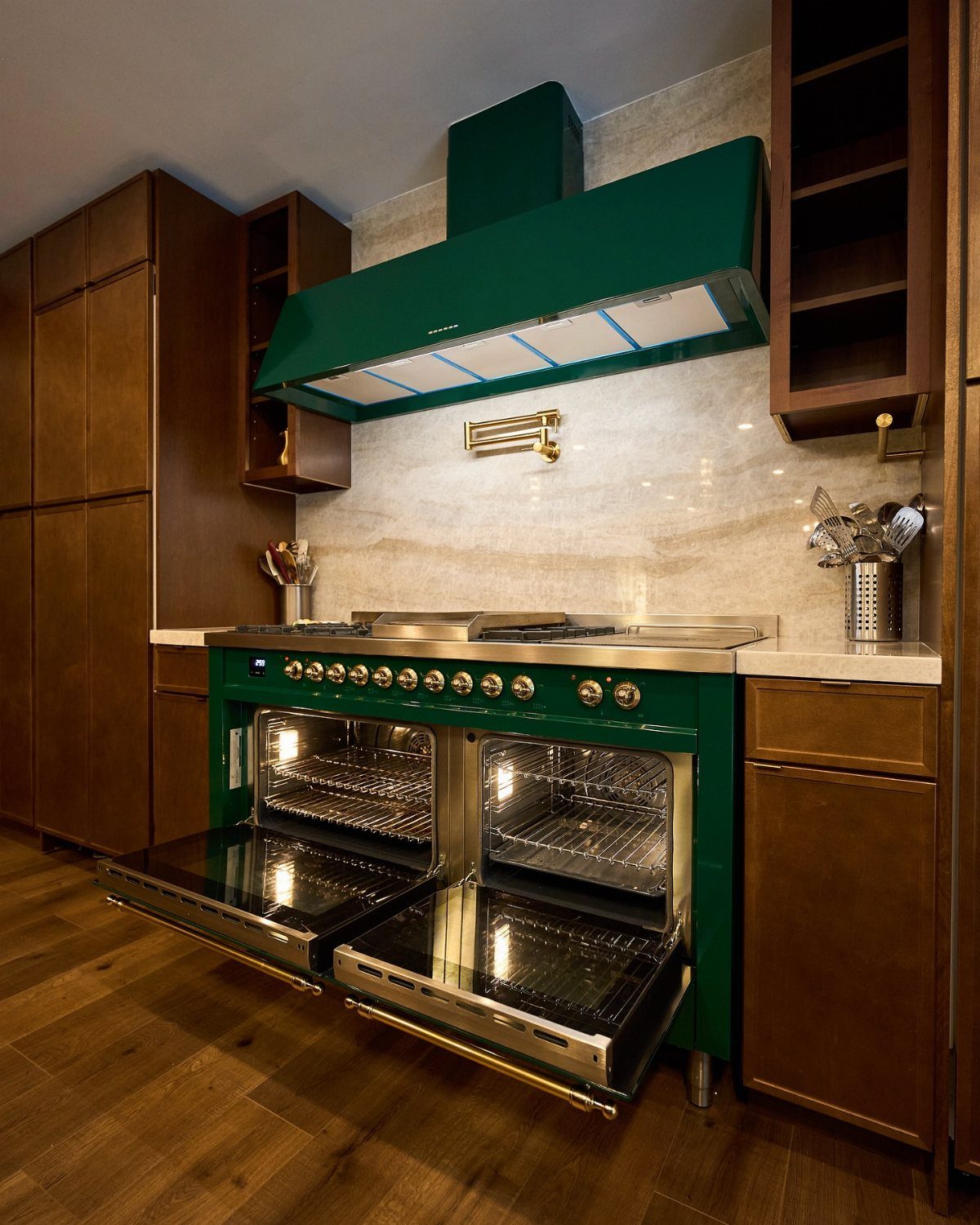 Dark green range and vent hood surrounded by dark brown wooden kitchen cabinets.