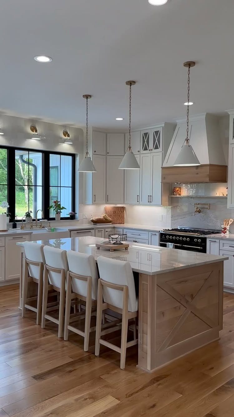 Farmhouse kitchen with white cabinets and a seamless marble slab backsplash behind the stove.