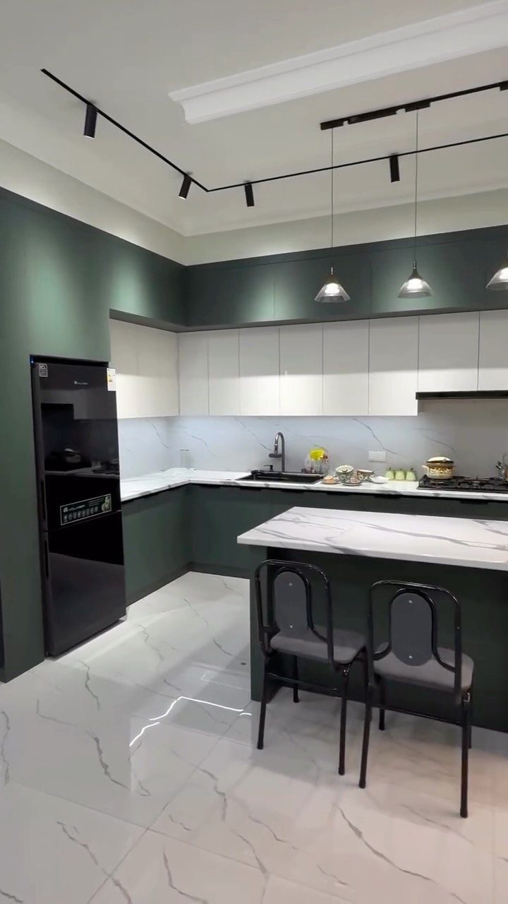 Modern kitchen with dark green cabinetry, white upper cabinets, and white marble floors.