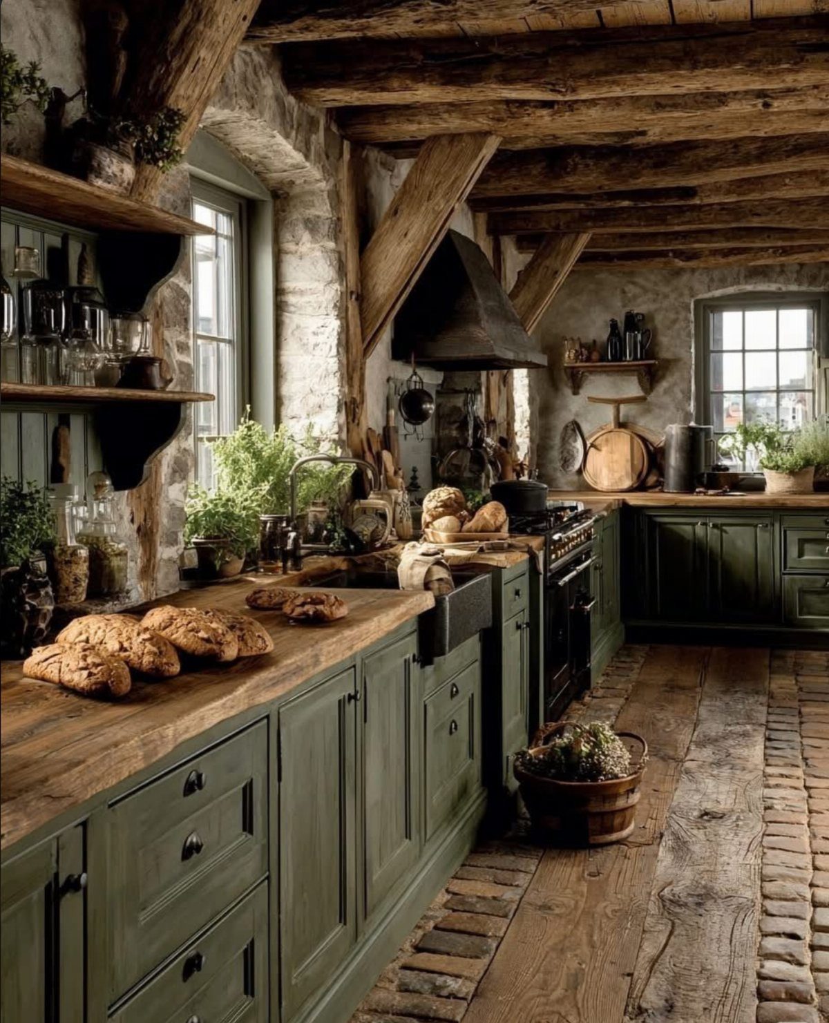 Olive green kitchen cabinets with wooden countertops in a rustic stone room.