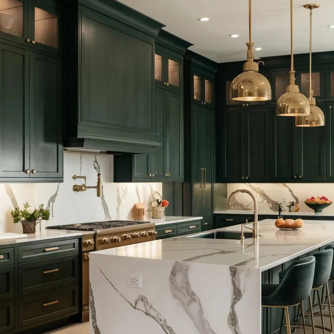 Emerald green kitchen cabinets with gold brass hardware and white marble countertops.