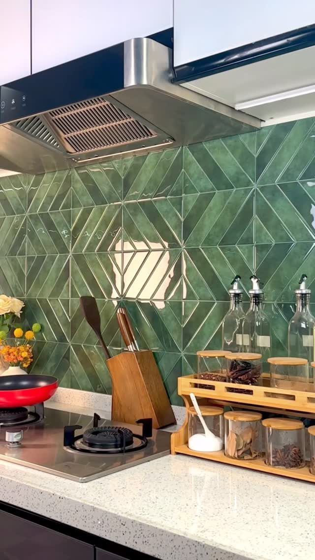 Green geometric star pattern tiles on a kitchen backsplash with a white countertop.