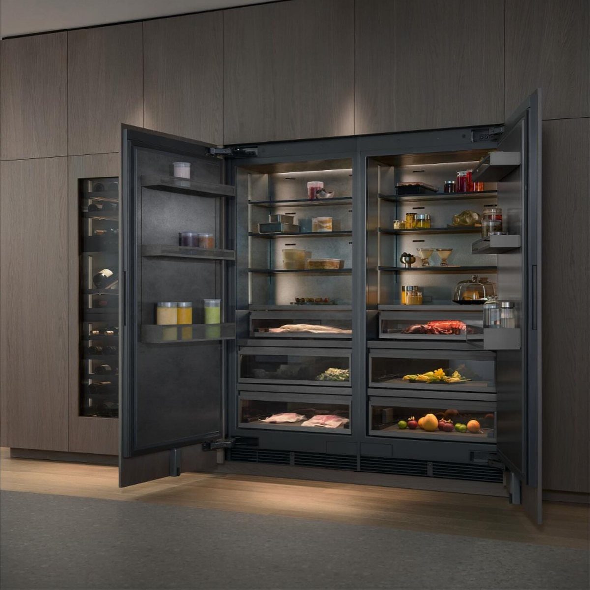 Professional stainless steel refrigerator with open doors in a modern dark wood kitchen