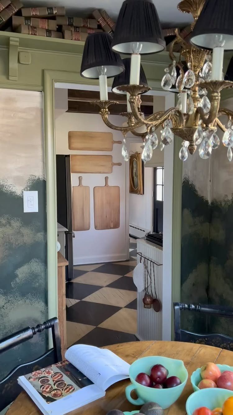 Black and white checkered kitchen floor seen through a doorway with a chandelier.
