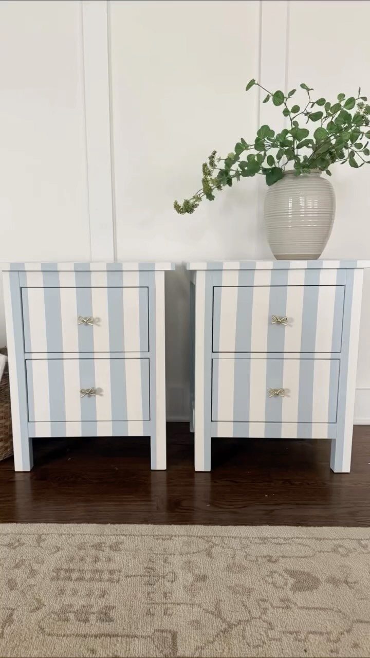 Two striped blue and white cabinets with gold handles and a potted plant.