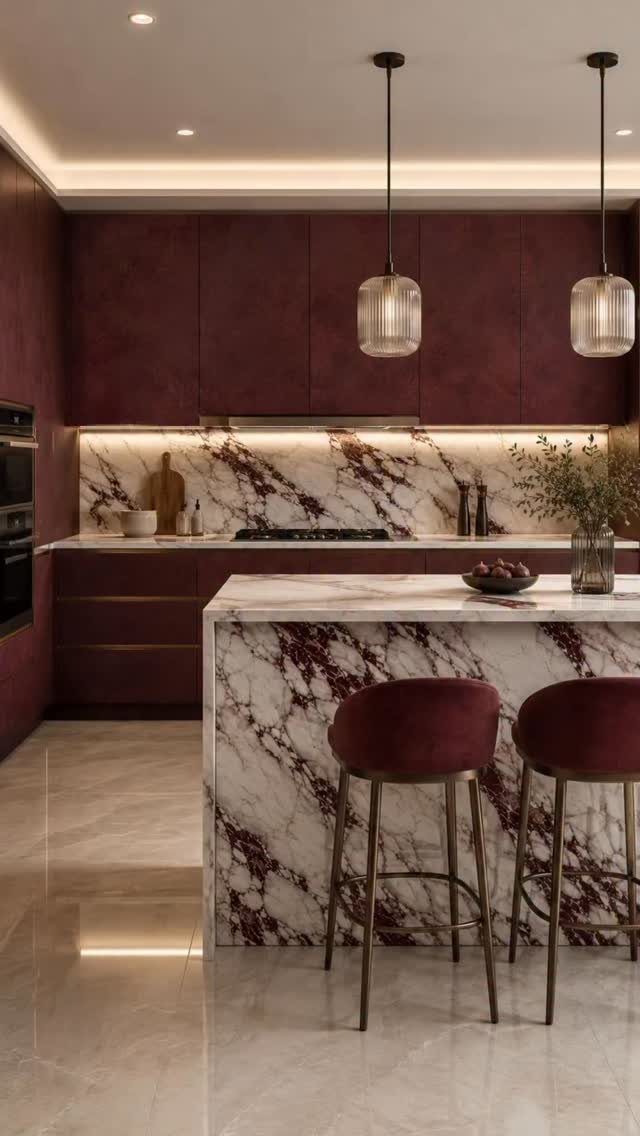 Modern kitchen with burgundy cabinets, marble island, and velvet bar stools.