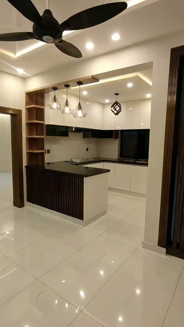 Modern kitchen with white cabinets, dark countertops, and a slatted wood island.