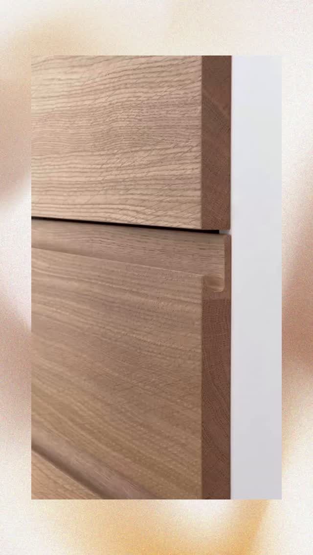 Light wood kitchen cabinets with a handleless recessed grip design and natural grain.