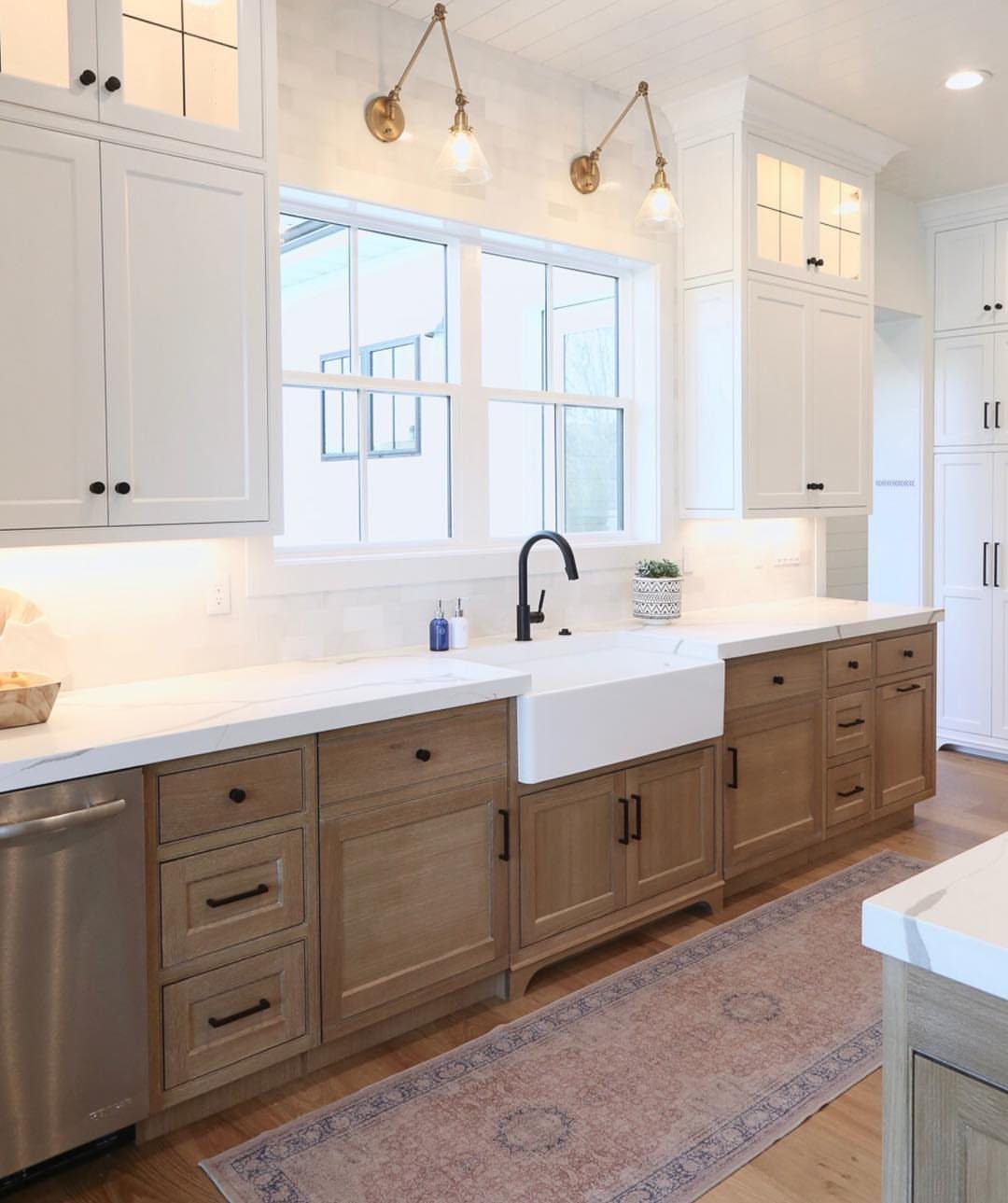 White upper cabinets and light wood lower cabinets with white countertops and farmhouse sink