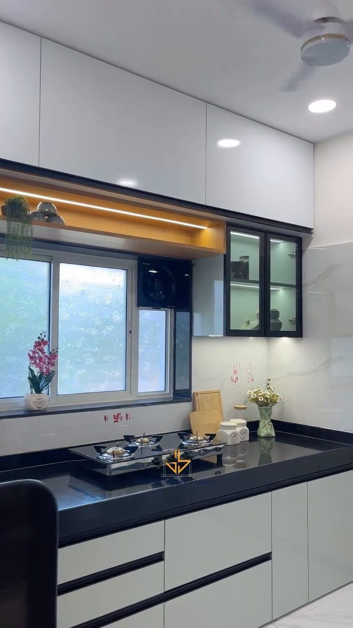 White kitchen cabinets with black trim and a solid black monochrome countertop.