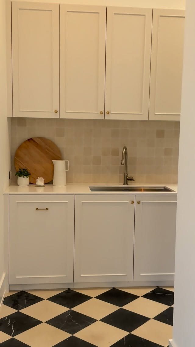 Small butler's pantry with white cabinetry, a prep sink, and checkered marble flooring.