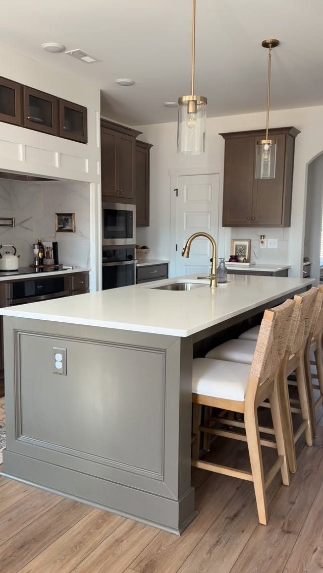 Grey kitchen island with a recessed back panel and white countertop