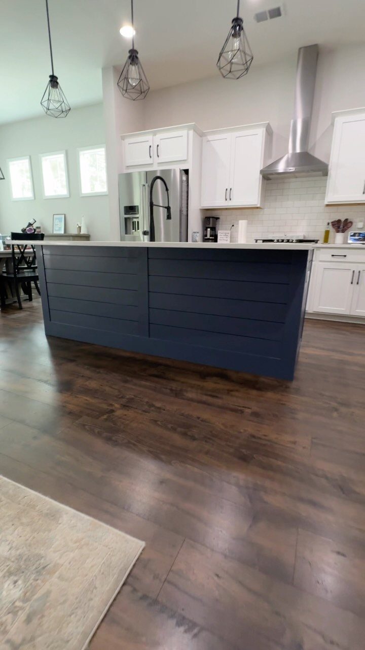 Navy blue kitchen island with horizontal shiplap paneling and white countertop