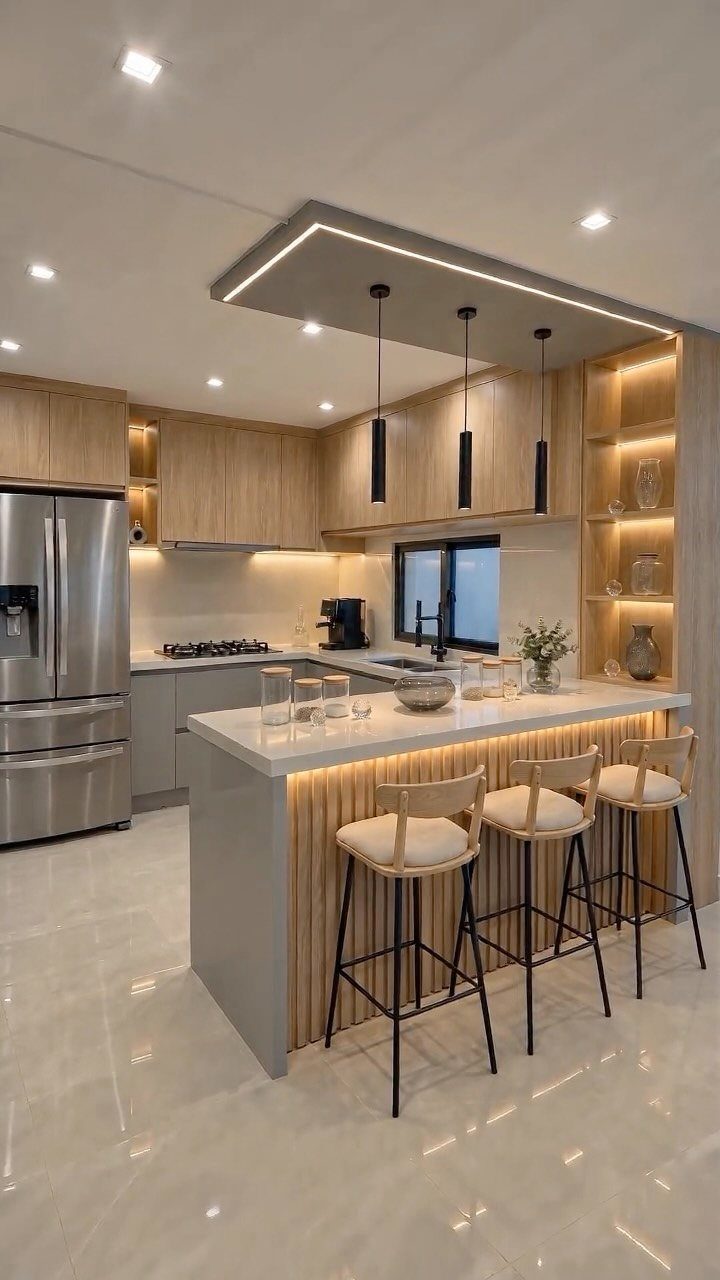Modern kitchen island with white countertop and three wooden bar stools with cushions.