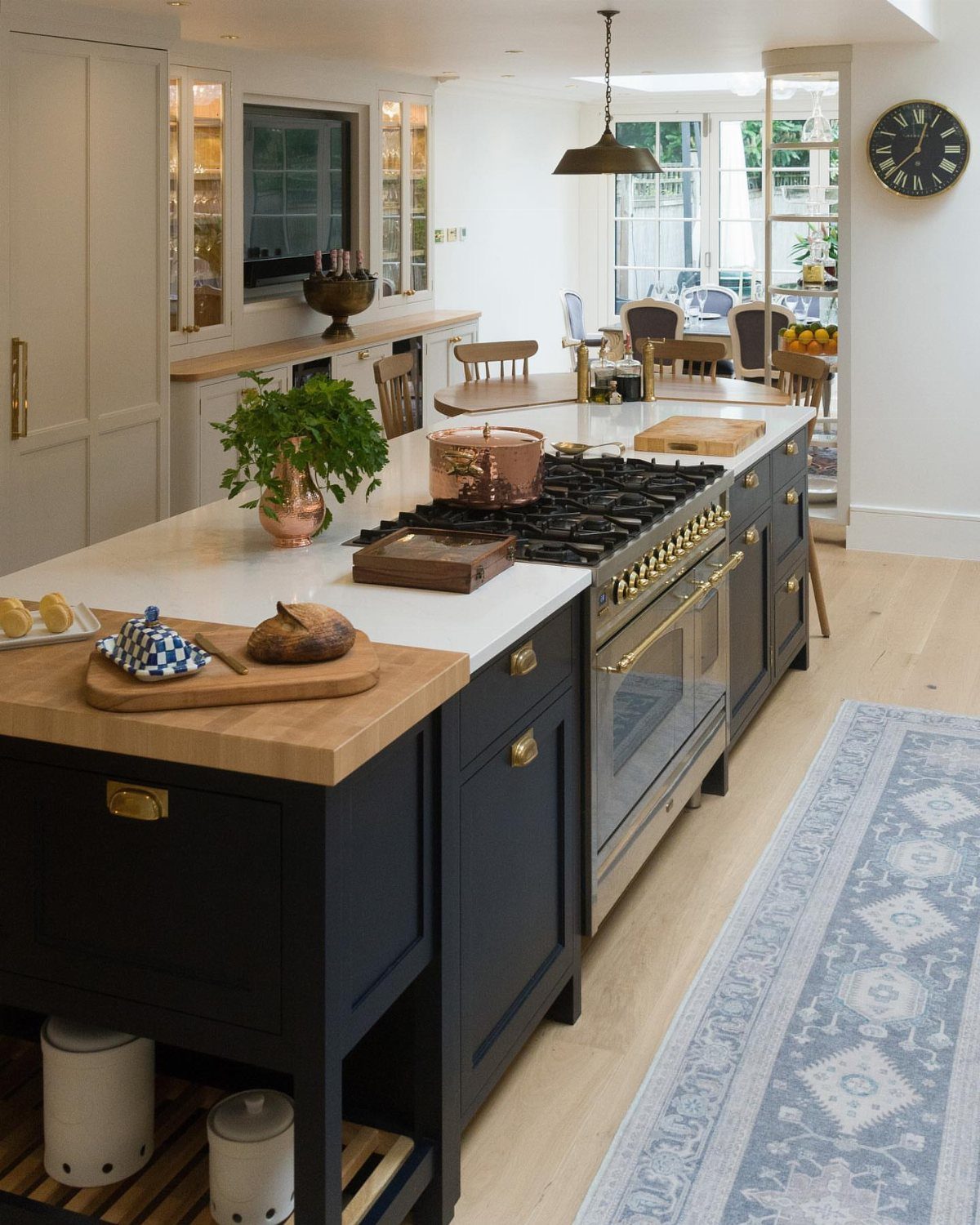 Navy blue kitchen island featuring a built-in gas stove and white countertops.