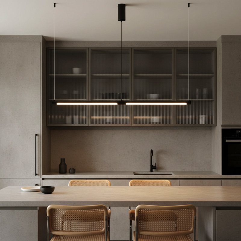 Linear black suspension light hanging over a modern kitchen sink and grey cabinets.