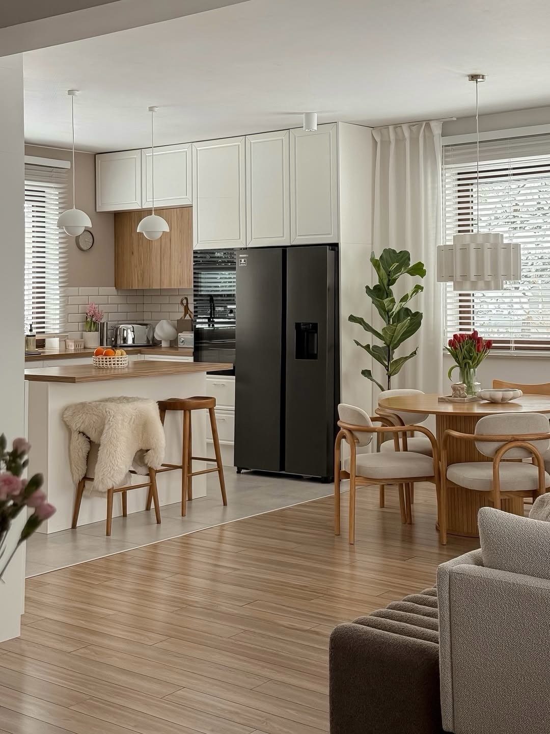 Grey sofa and wooden dining chairs in an open concept kitchen living area
