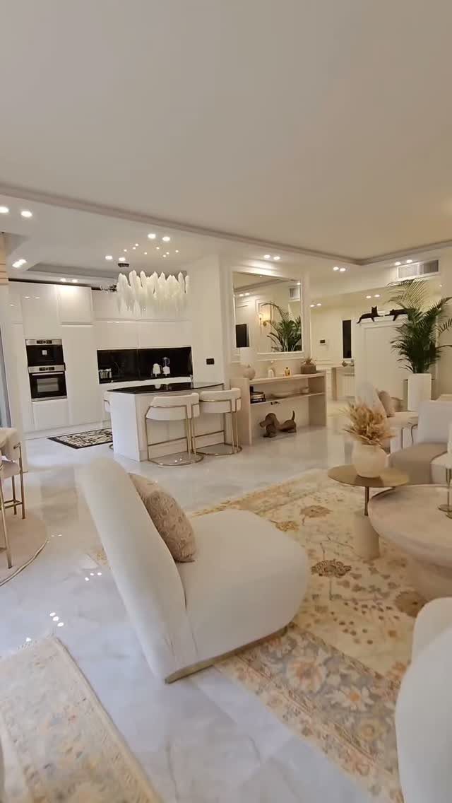 Modern open concept living room and kitchen with white furniture and marble floors