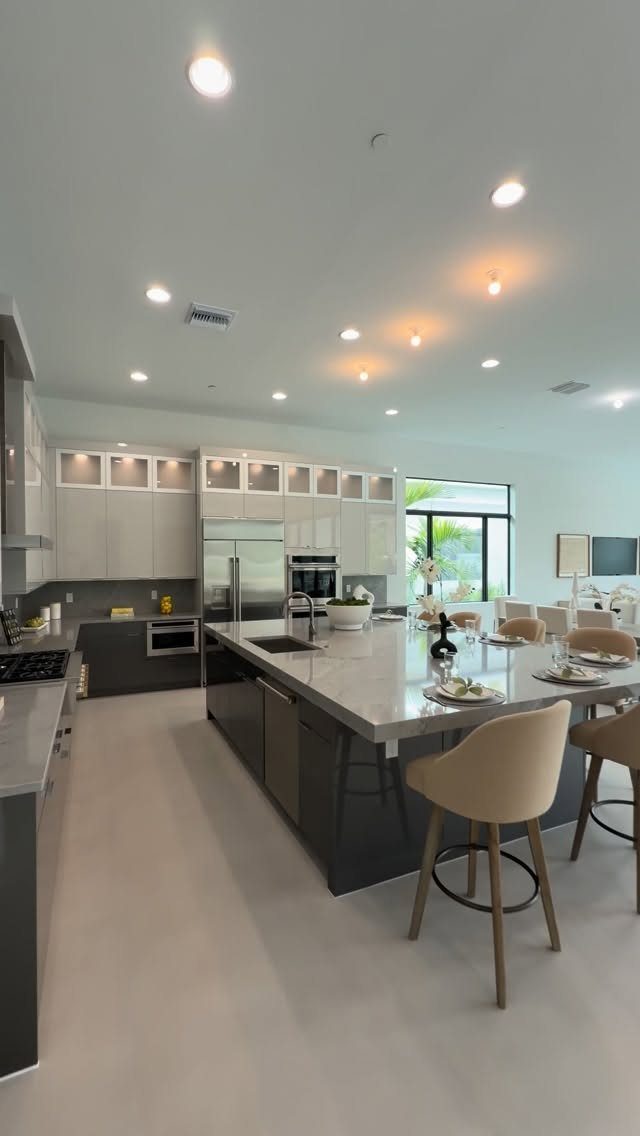 Modern open concept kitchen and living area with a large island and bar stools.