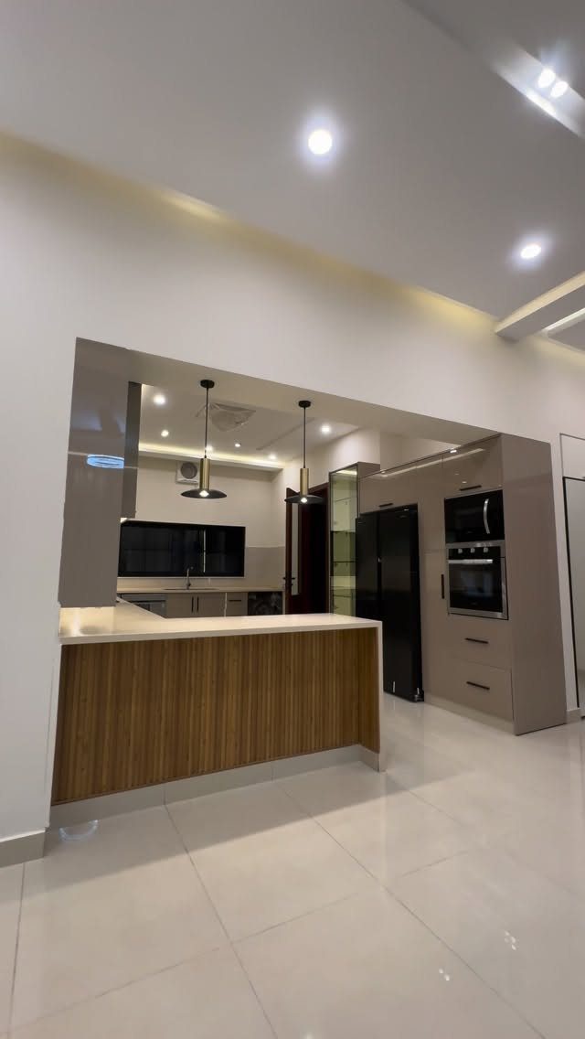 Modern open concept kitchen with wood cabinets and white tiled flooring