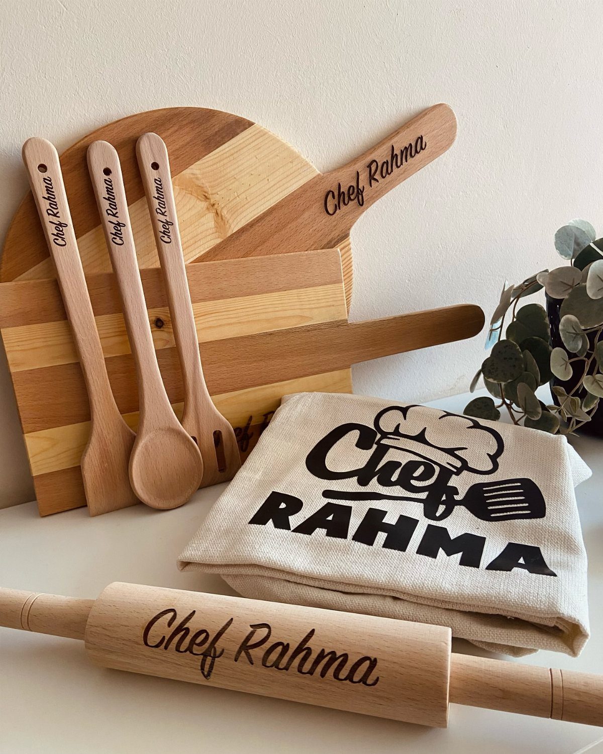 Personalized wooden kitchen utensils and a matching apron engraved with Chef Rahma.