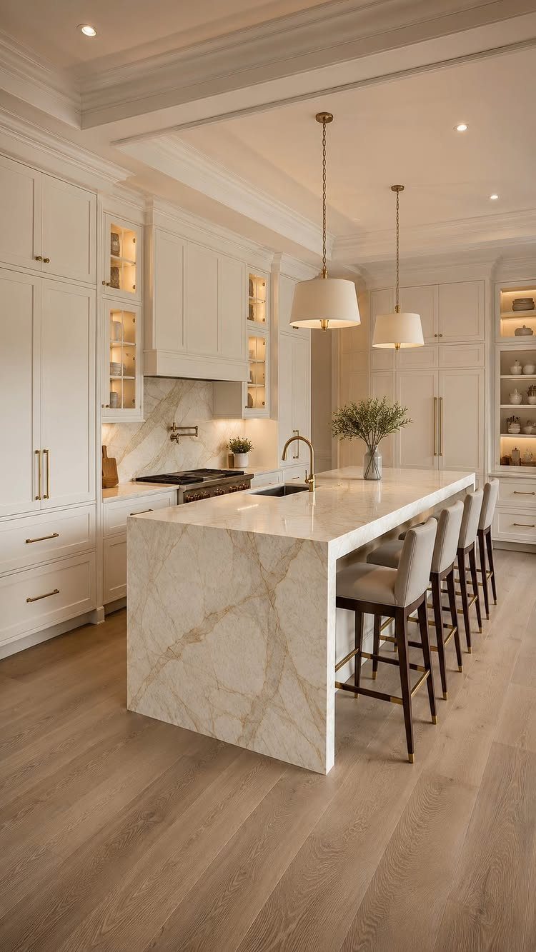 White quartz waterfall island in a modern kitchen with white cabinets and wood floors