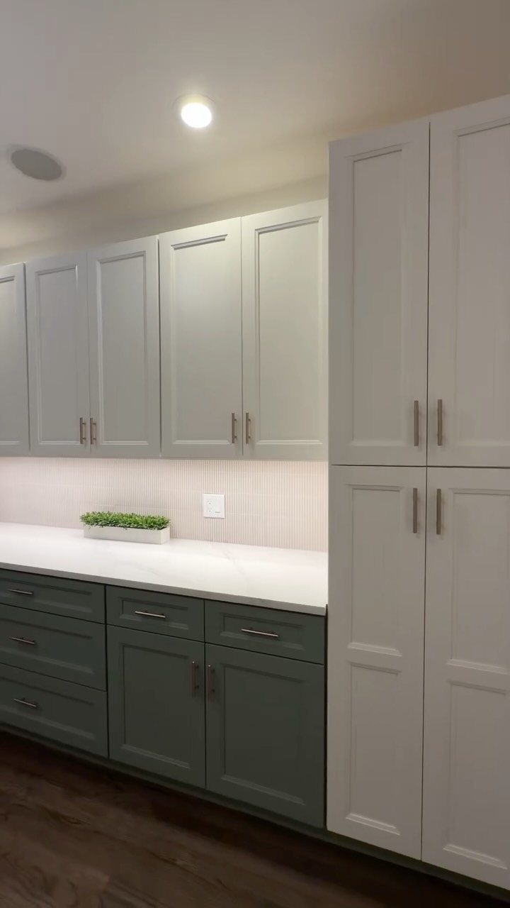 White upper and dark green lower cabinets in a one-wall kitchen layout.