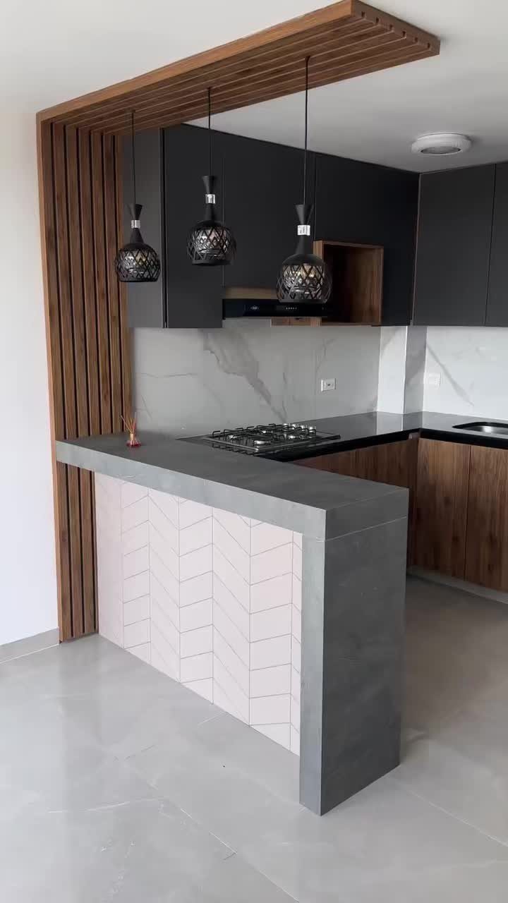 Modern small kitchen with grey concrete breakfast bar and pink herringbone tile accents.