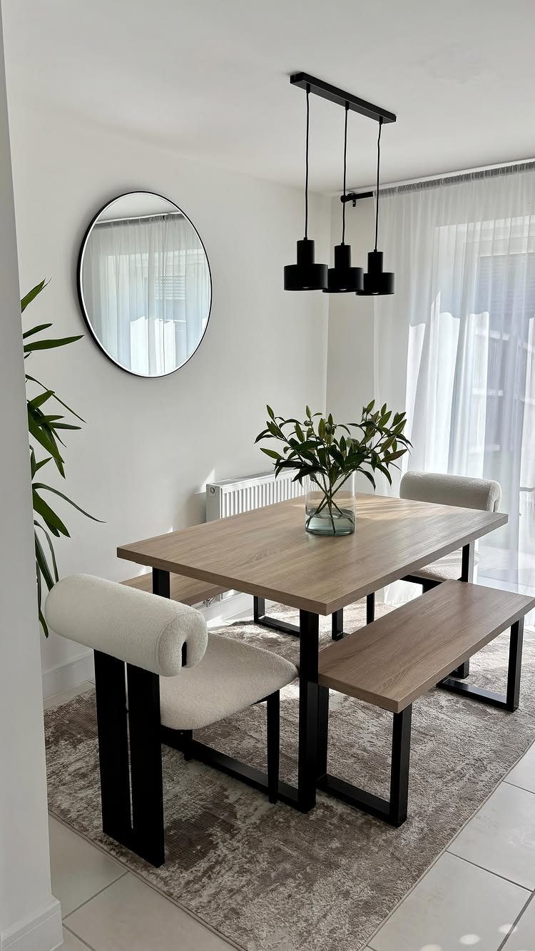 Light wood dining table and bench on a grey rug in a bright room