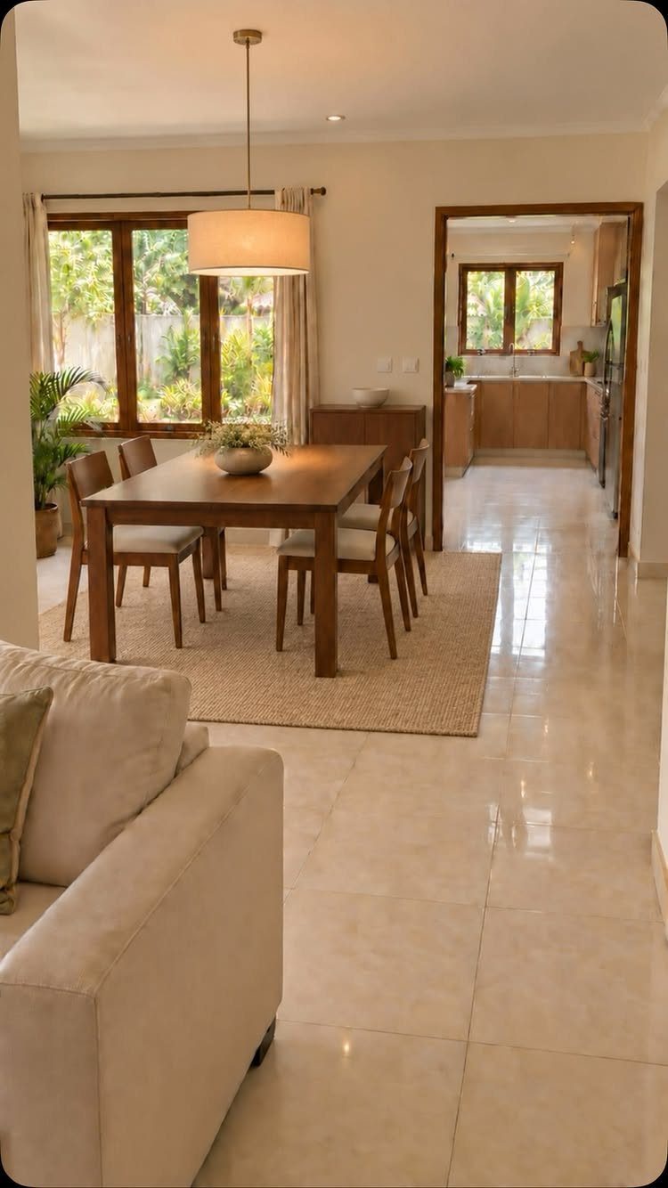 Wooden dining table and chairs on a tan woven rug in a bright room