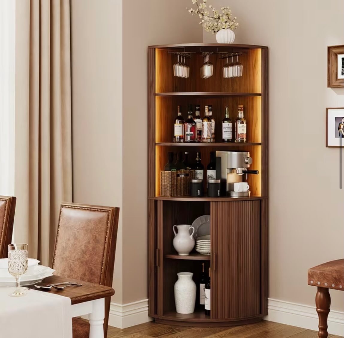 Curved dark wood corner cabinet with wine glasses, liquor bottles, and built-in lighting.