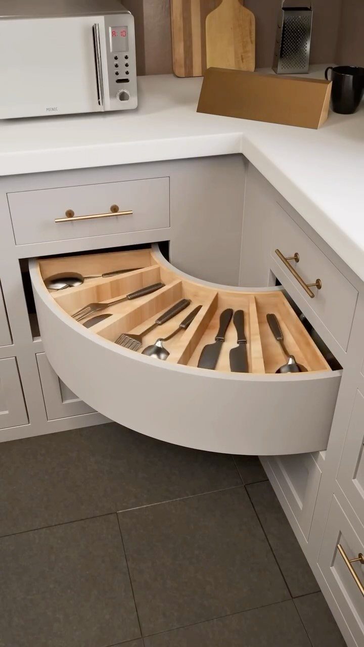 Curved pull-out corner cabinet drawer with cutlery in a grey kitchen
