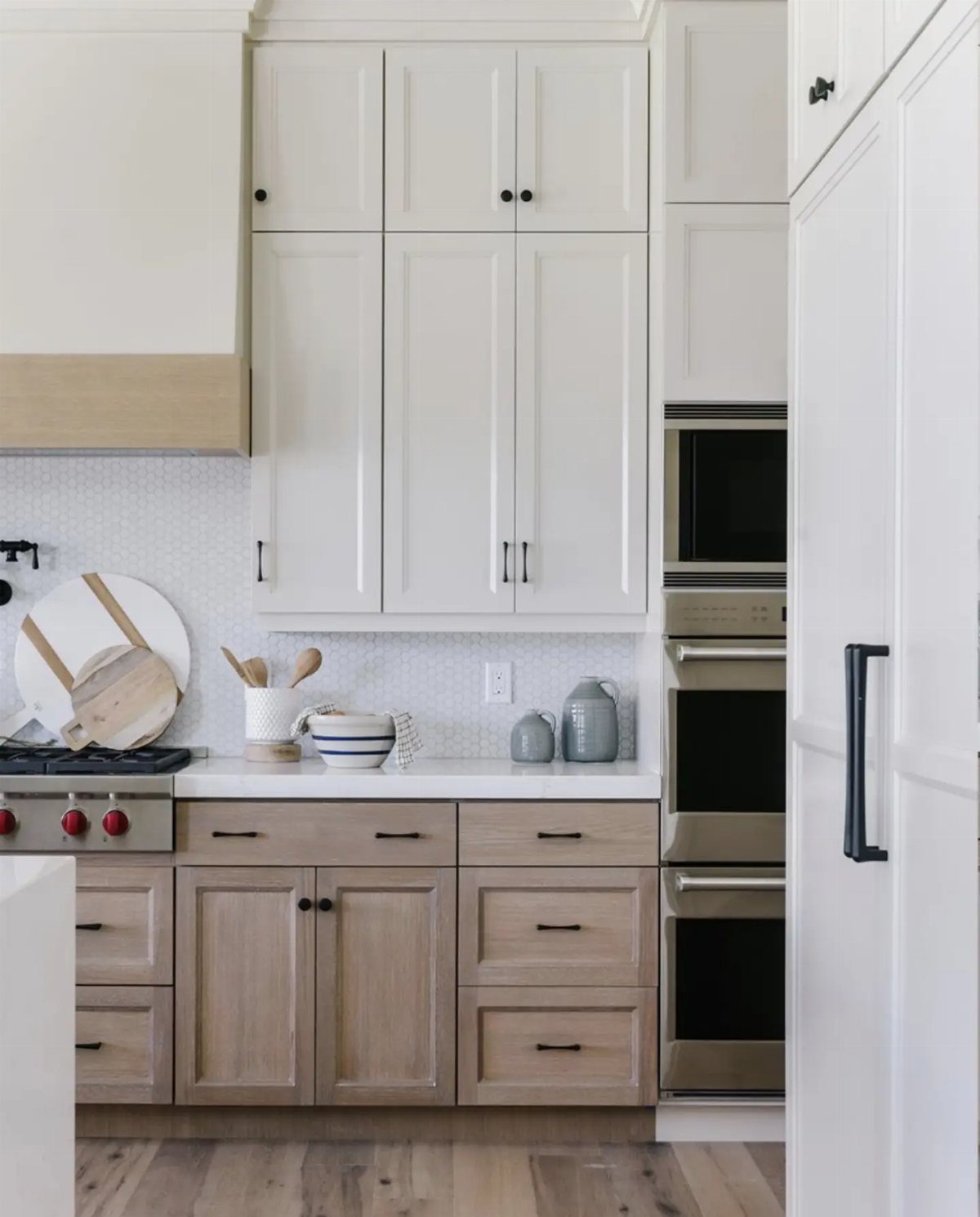 White upper cabinets extending to the ceiling in a modern light-toned kitchen.