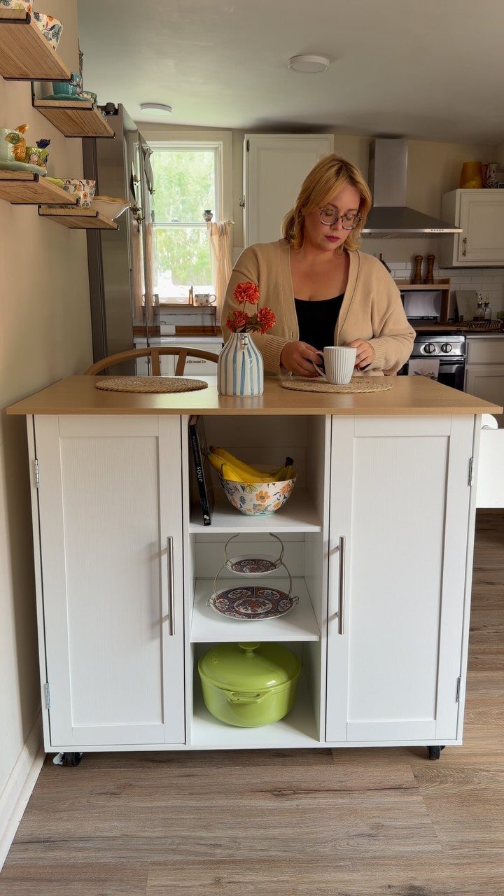 White mobile kitchen island with open shelves and a light wood countertop.