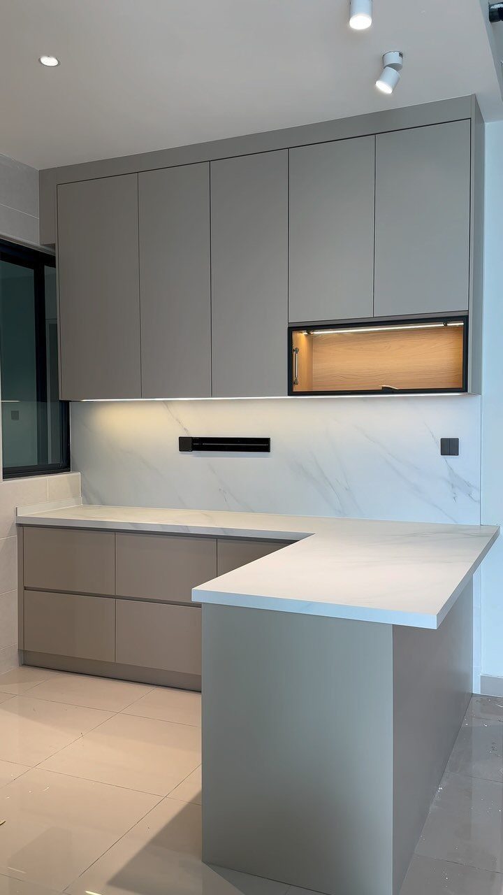 White quartz countertops and grey cabinets in a modern, minimalist kitchen setting.