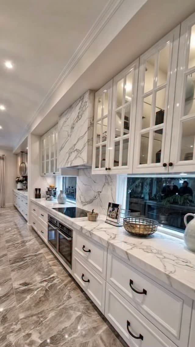 White quartz countertops and backsplash with grey marbling detail in a modern kitchen.