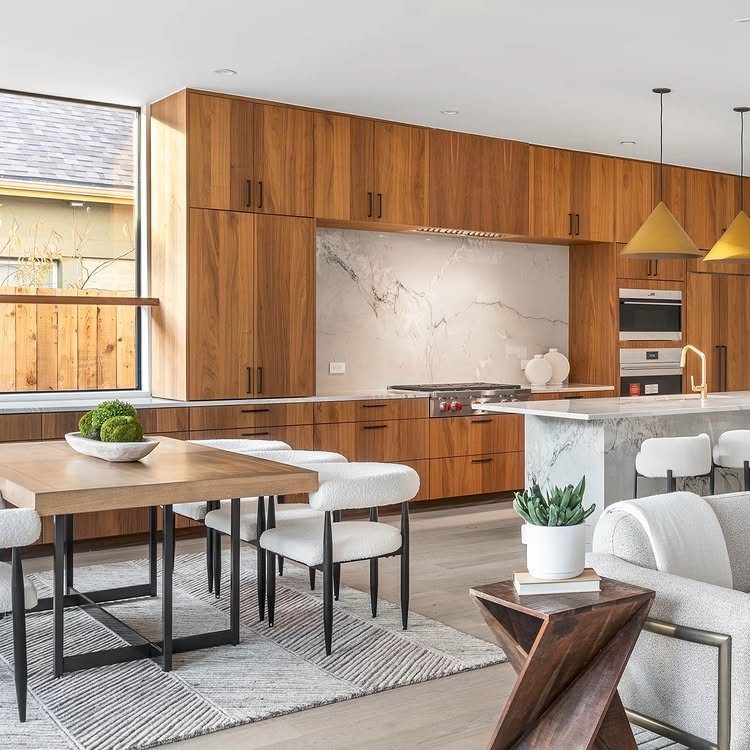 Walnut kitchen cabinets paired with white marble countertops and a matching backsplash.