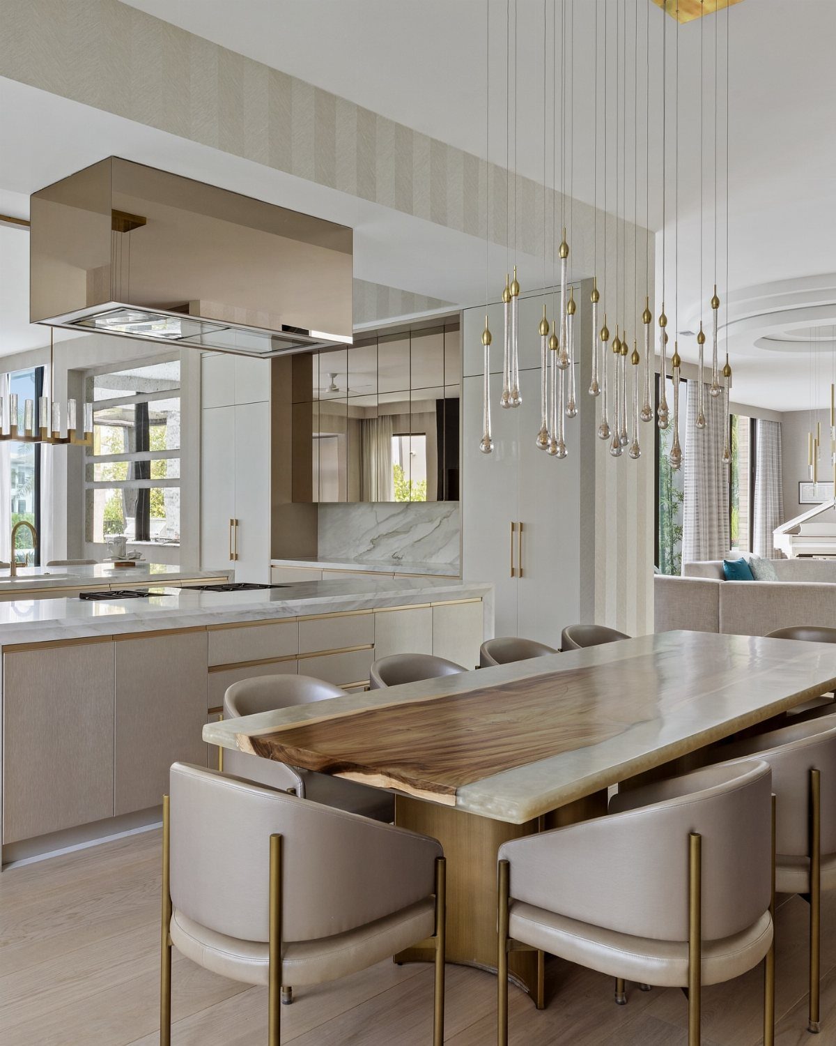Modern gold multi-pendant light fixture hanging over a marble kitchen dining table