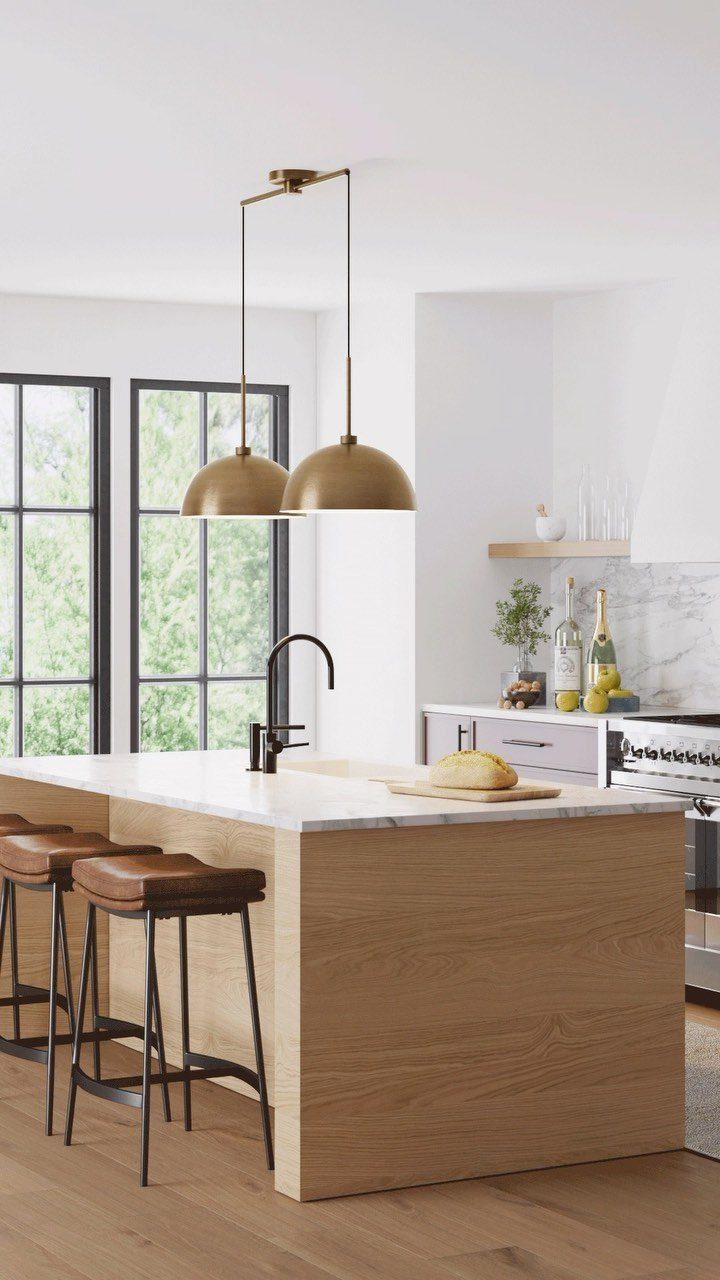 Gold dome pendant lights hanging over a white marble kitchen island with stools.