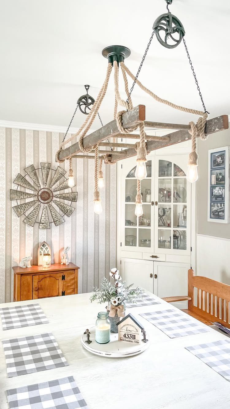 Rustic wooden rope chandelier with exposed bulbs hanging over a white kitchen table